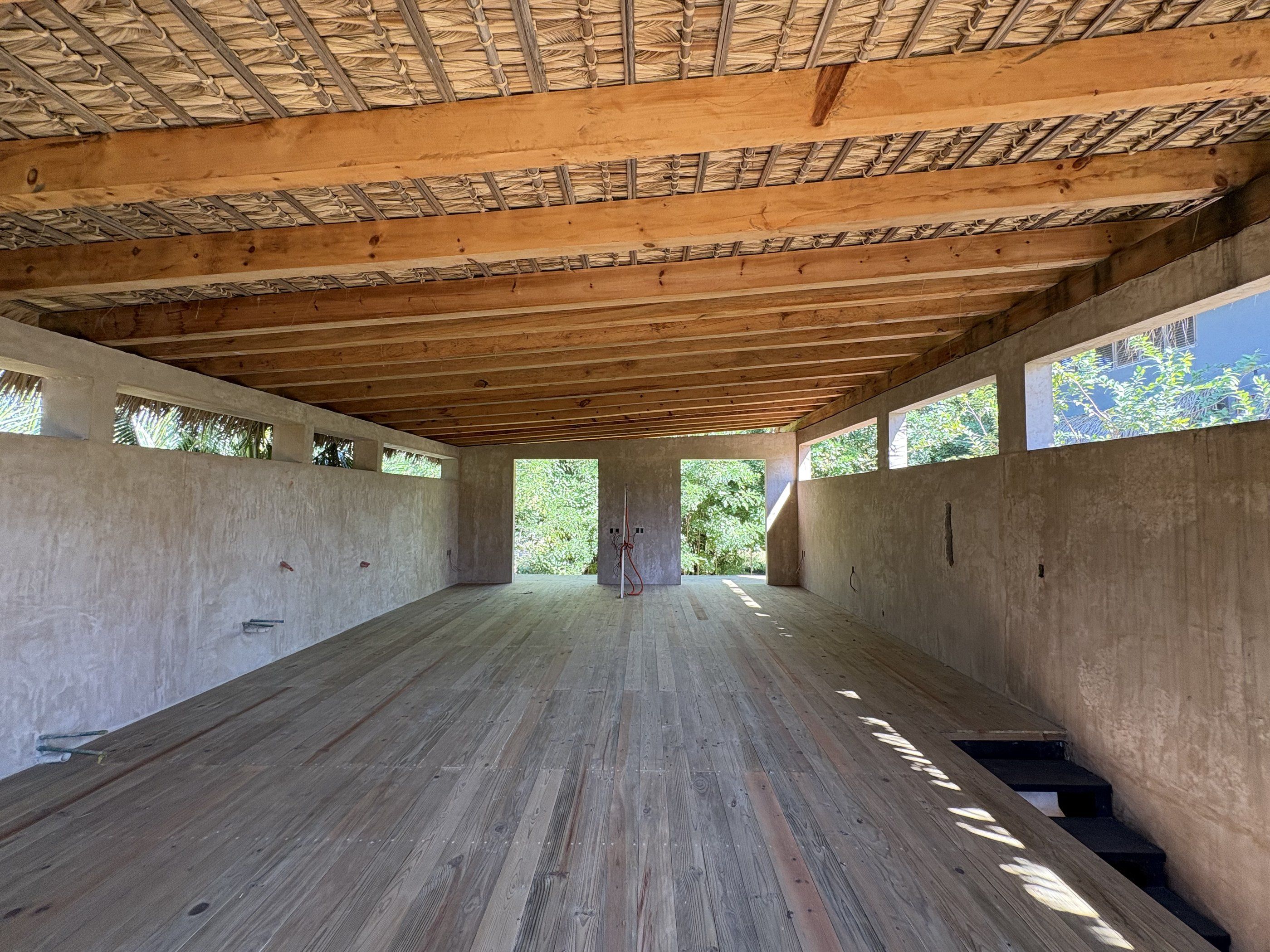 Espacio abierto en planta alta con vigas de madera, en obra, Casa Balsa