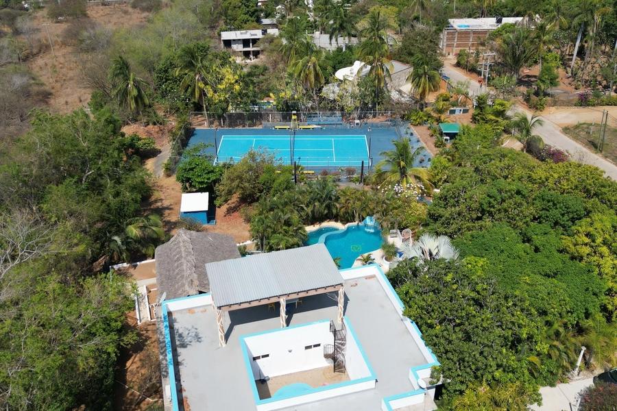 Top-down aerial view of the house, pools and tennis court next to the ocean, Casa Los Mangos, Zicatela