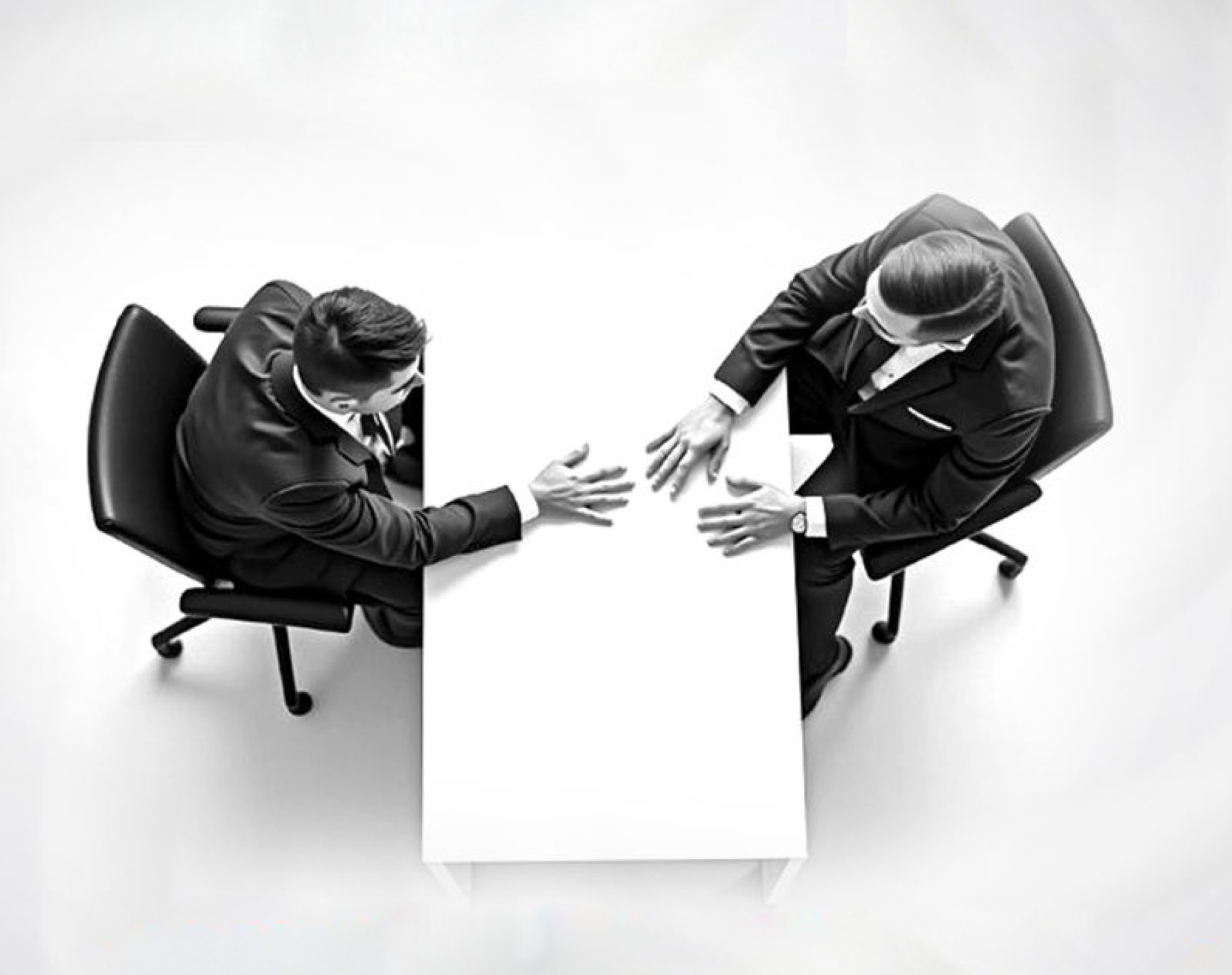 Two business executives meeting across a desk to align on AI strategy