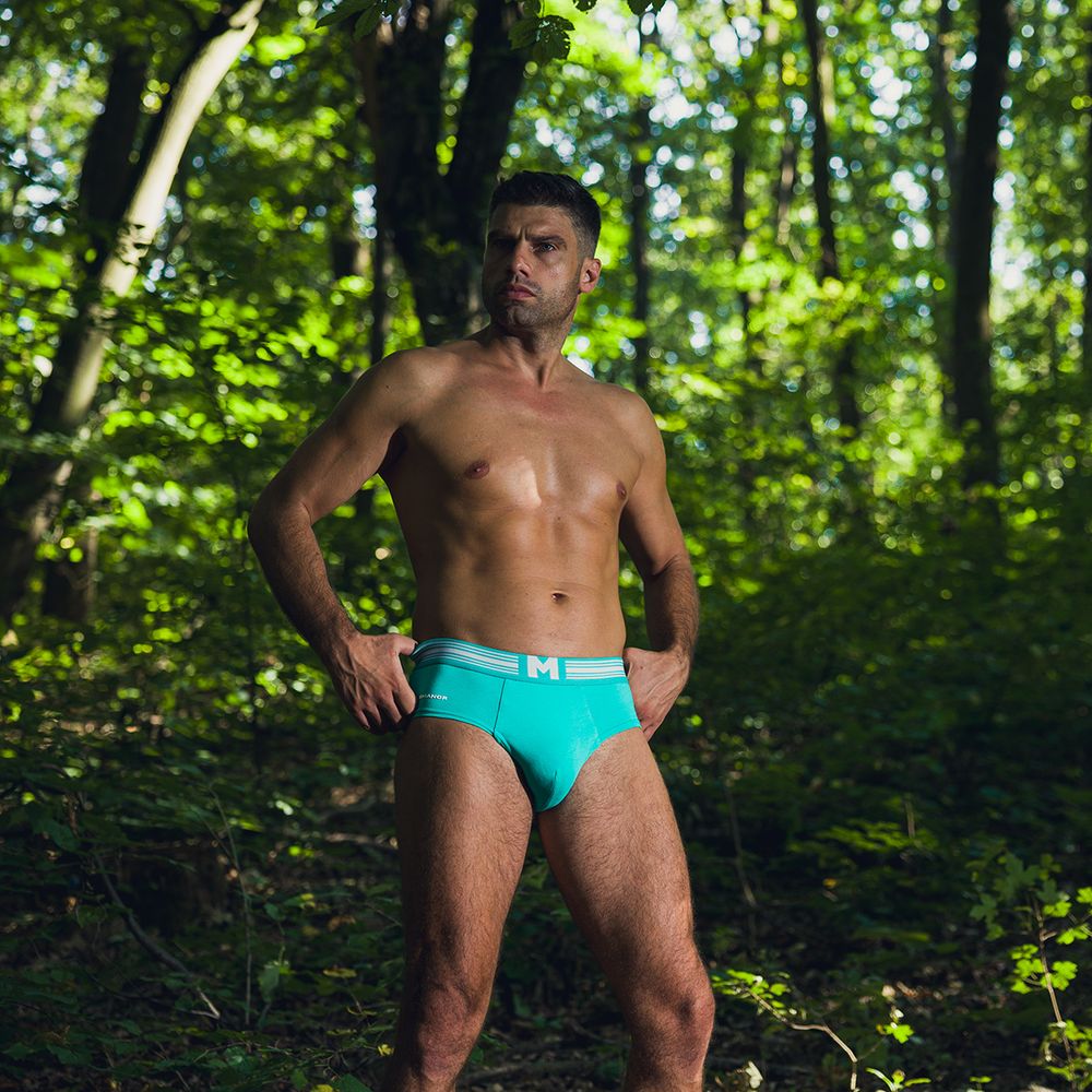 Muški model u zelenim slipovima u prirodnom okruženju, profesionalna underwear fotografija muškog donjeg veša na otvorenom