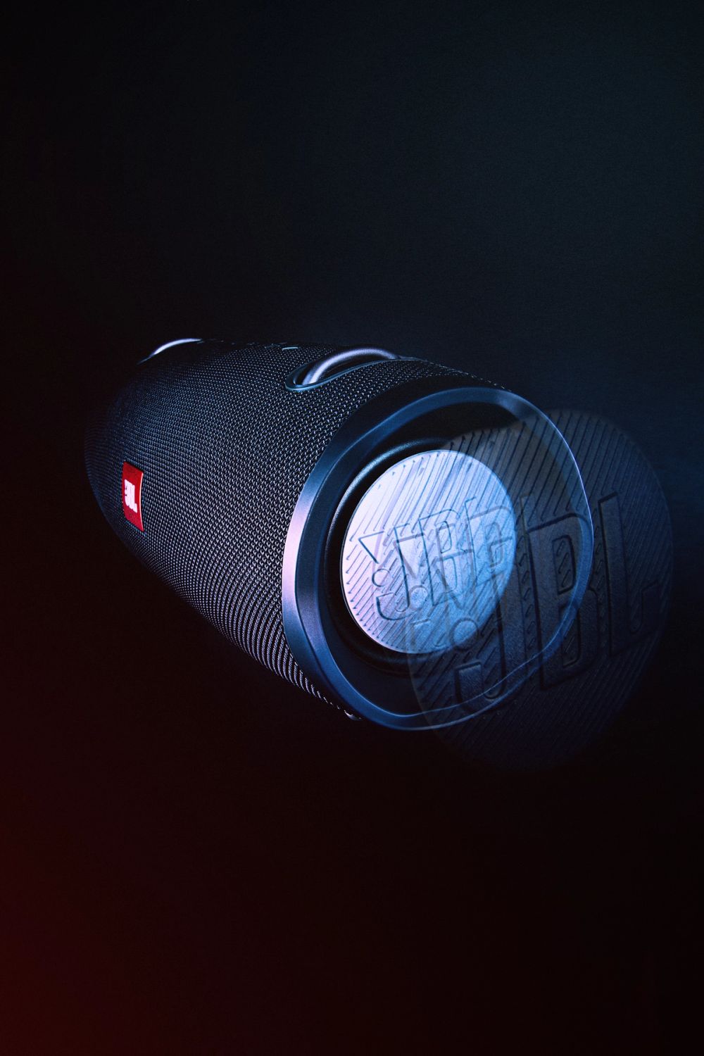 Produkt fotografija bluetooth zvučnika snimljena u studijskim uslovima, sa tamnom pozadinom i kontrastnim osvetljenjem koje naglašava teksturu, oblik i dizajn uređaja.