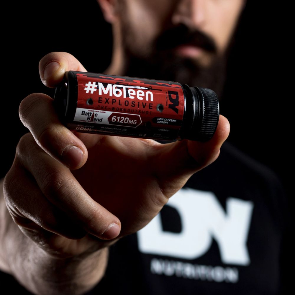 Produkt fotografija pre-workout suplementa u ruci sportiste, sa naglašenim detaljima ambalaže i dramatičnim osvetljenjem koje komunicira snagu i energiju.