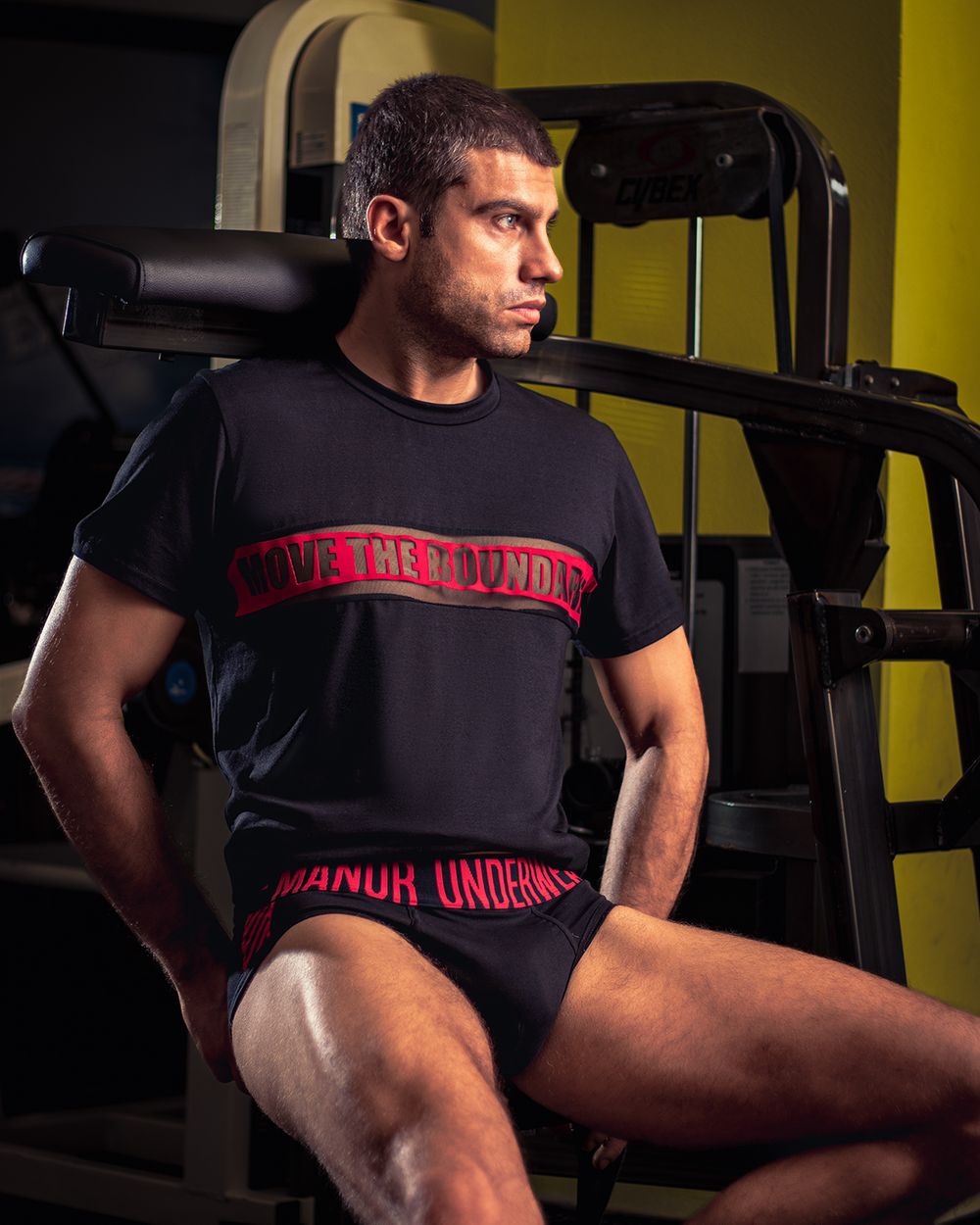 Muški model u donjem vešu i majici u teretani, profesionalna underwear fotografija u fitness ambijentu