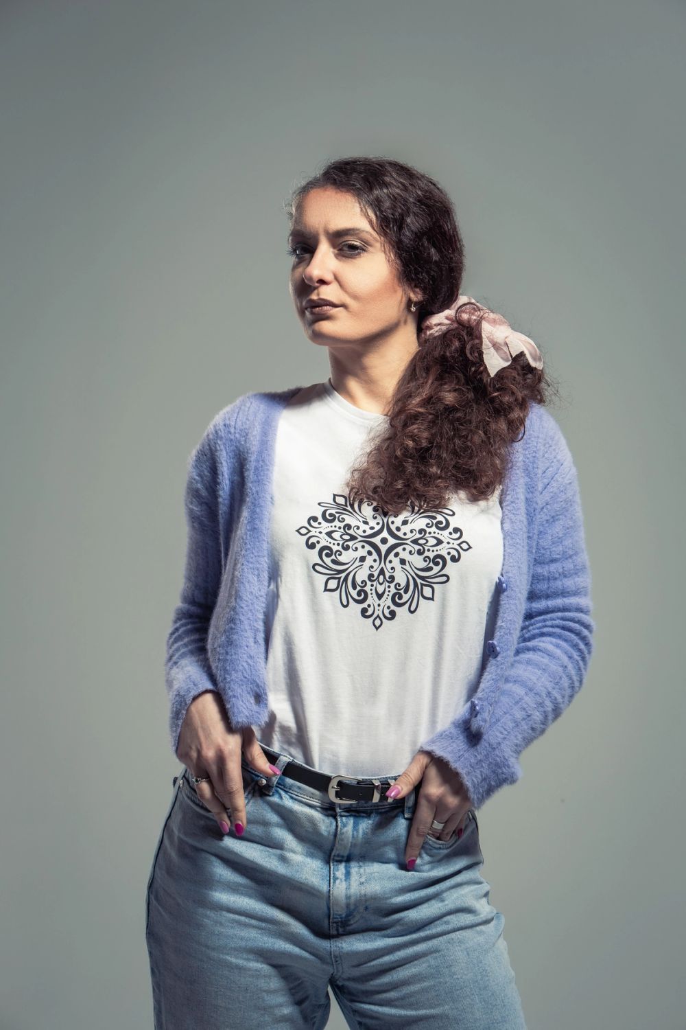 Studijski portret žene u ležernoj odevnoj kombinaciji, fotografisan na neutralnoj pozadini sa mekim svetlom i naglaskom na prirodan izraz, držanje tela i čistu kompoziciju.