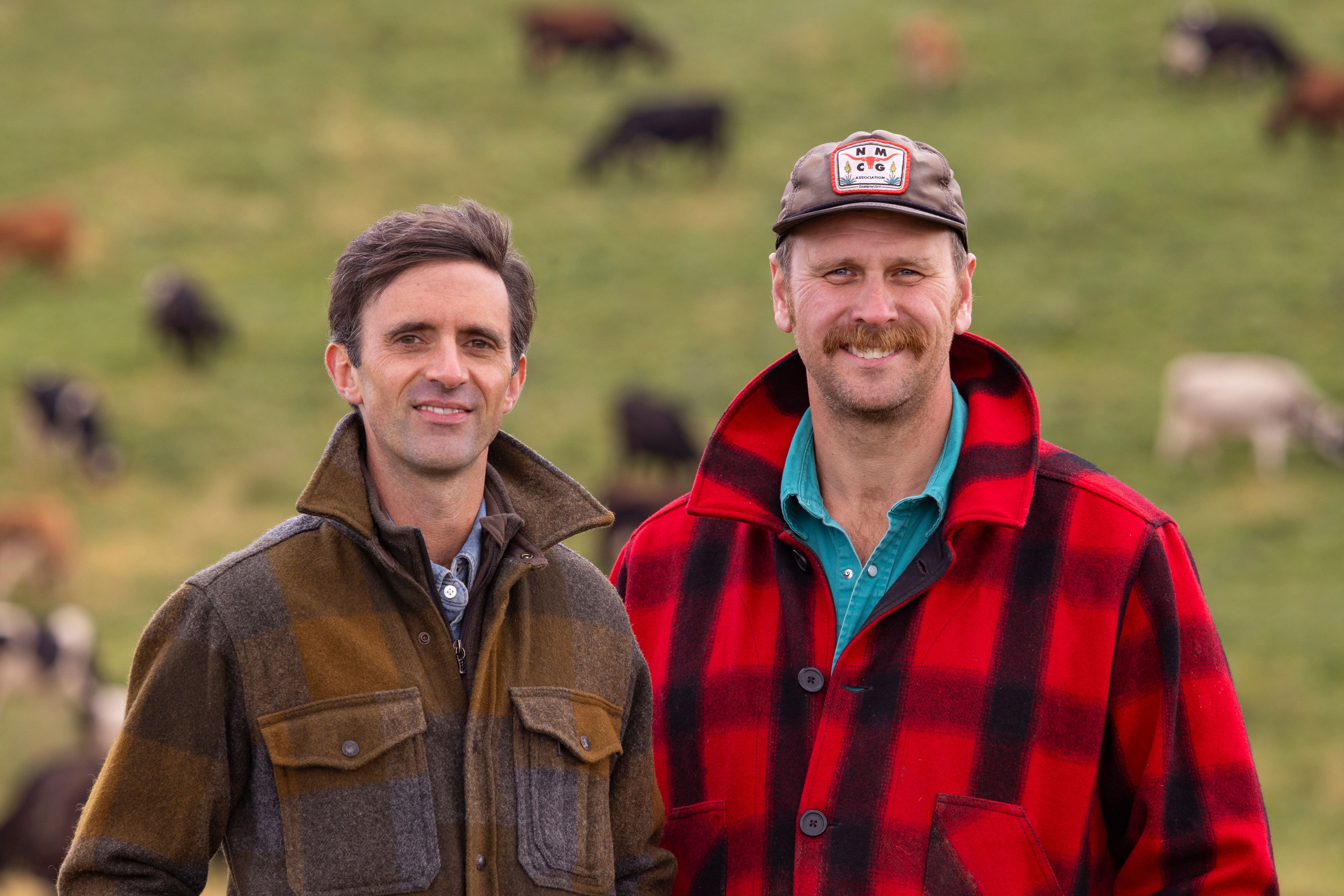 The farm families with their dogs, cows grazing behind them