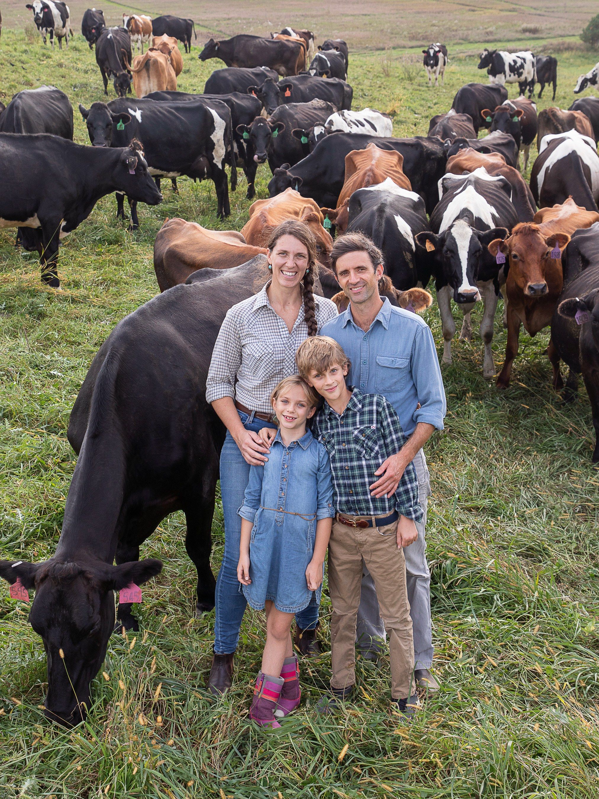 The Hatch family standing with their herd in the pasture