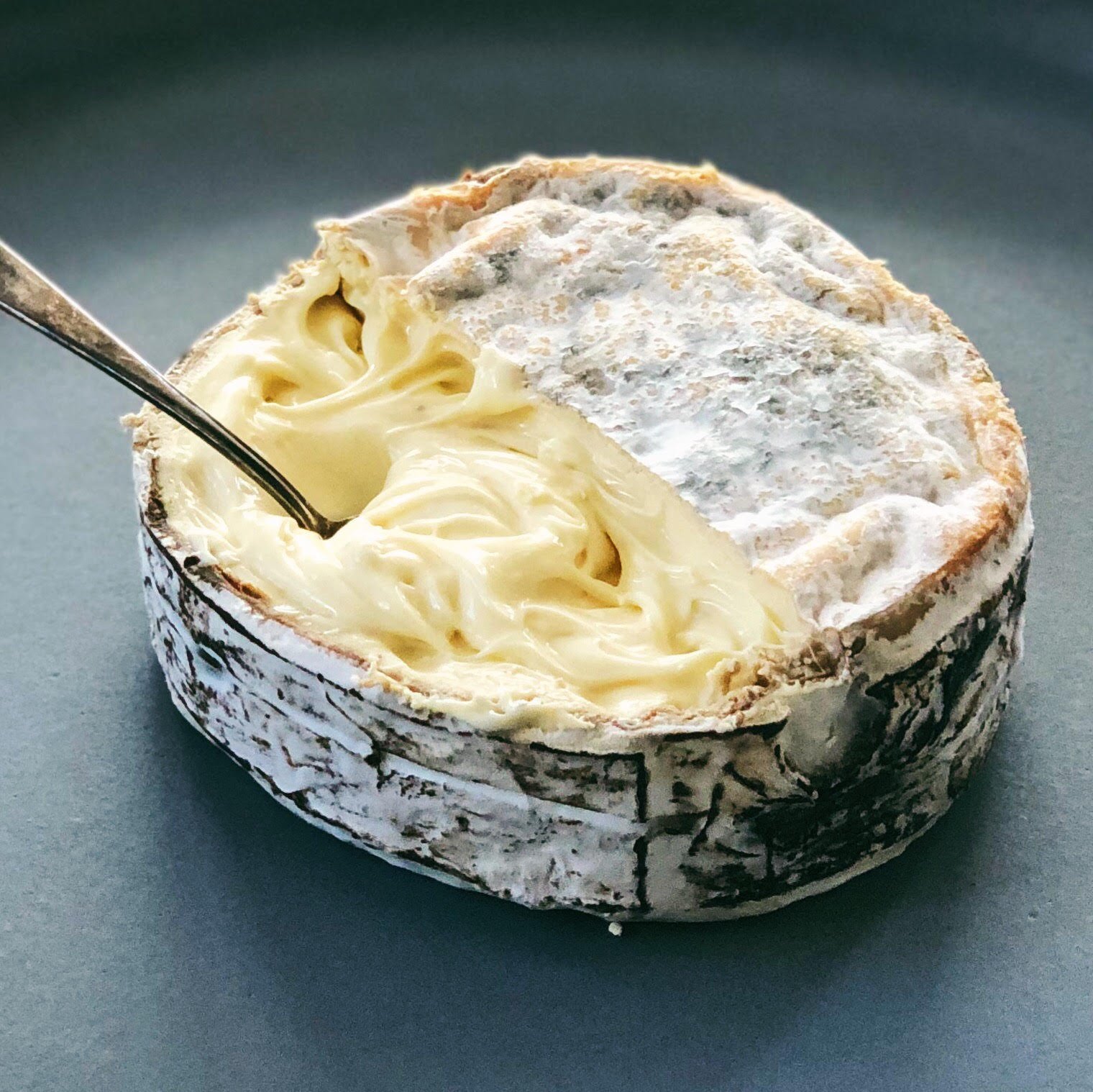 An opened wheel of Rush Creek Reserve with a spoon in the soft center