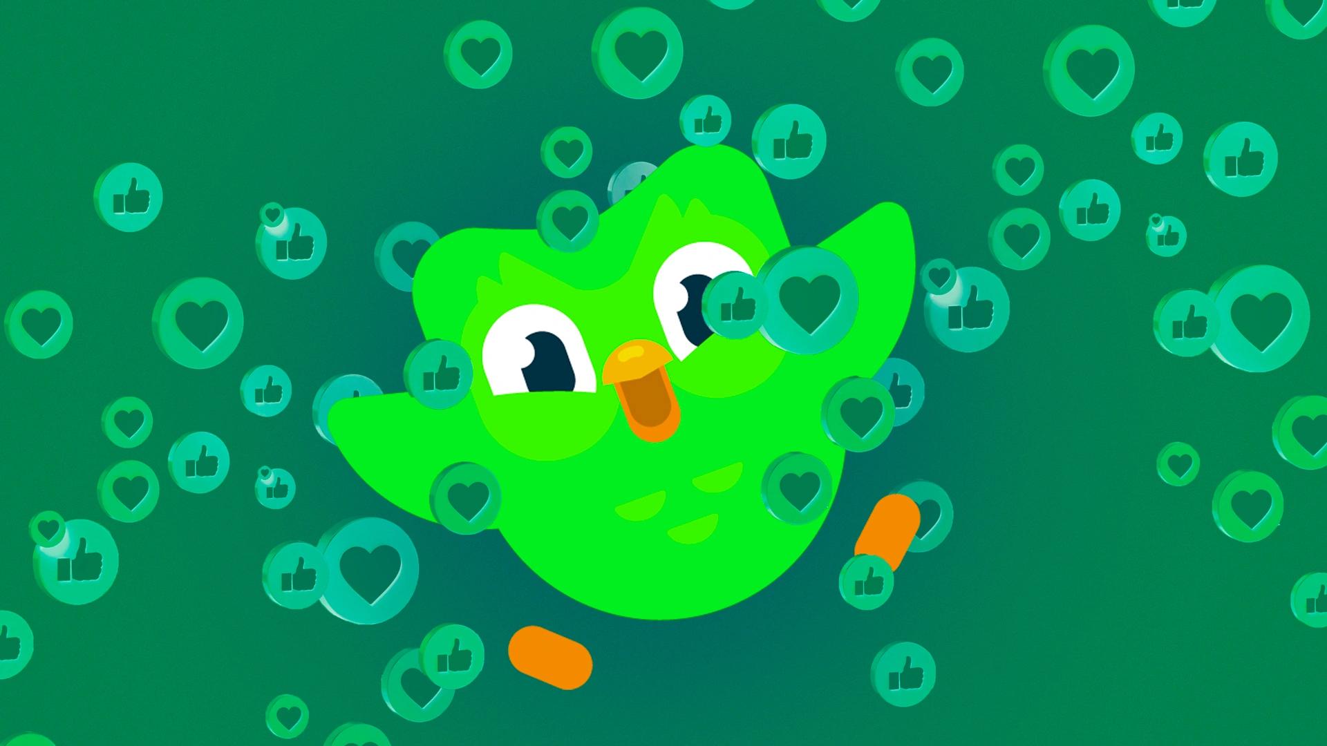 Duo, the green Duolingo owl, surrounded by floating heart and thumbs-up icons on a green background.