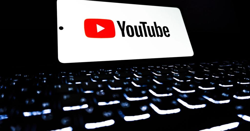 YouTube logo on a screen above a backlit keyboard.