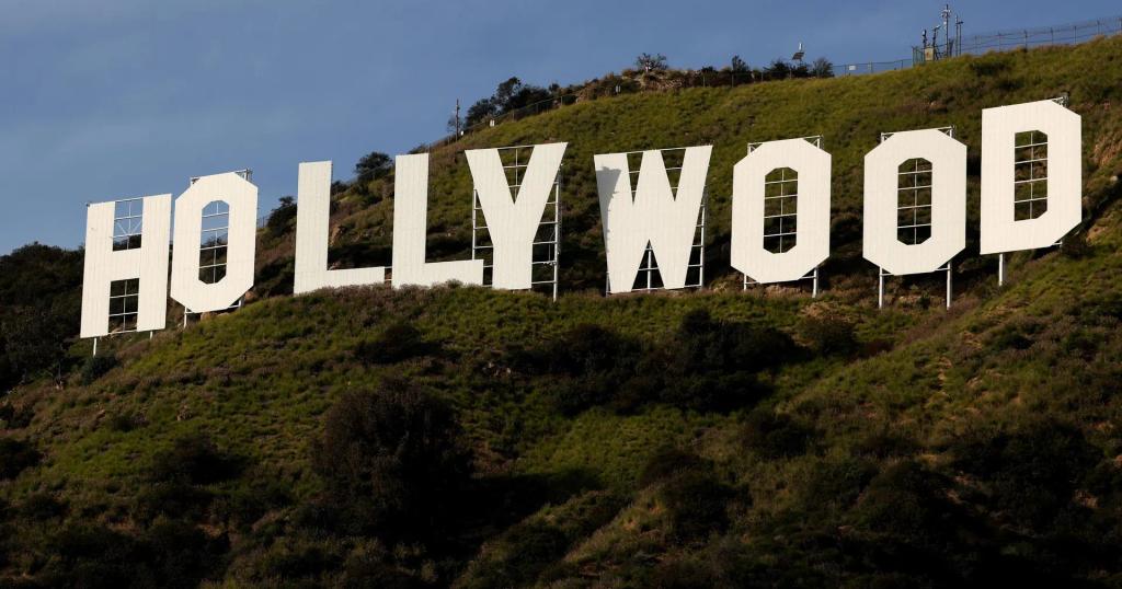 The large white Hollywood sign on a green hillside.