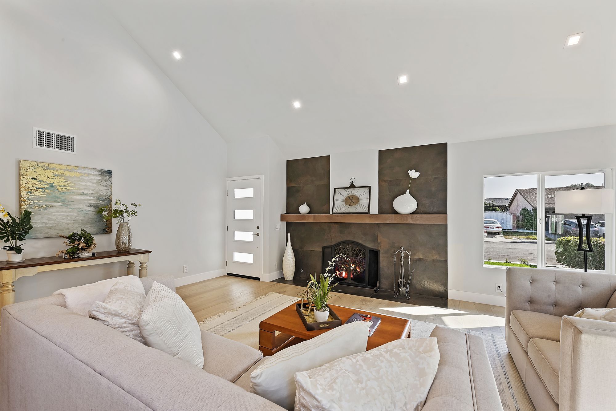 Family living room with sleek furniture, a fireplace, and natural light