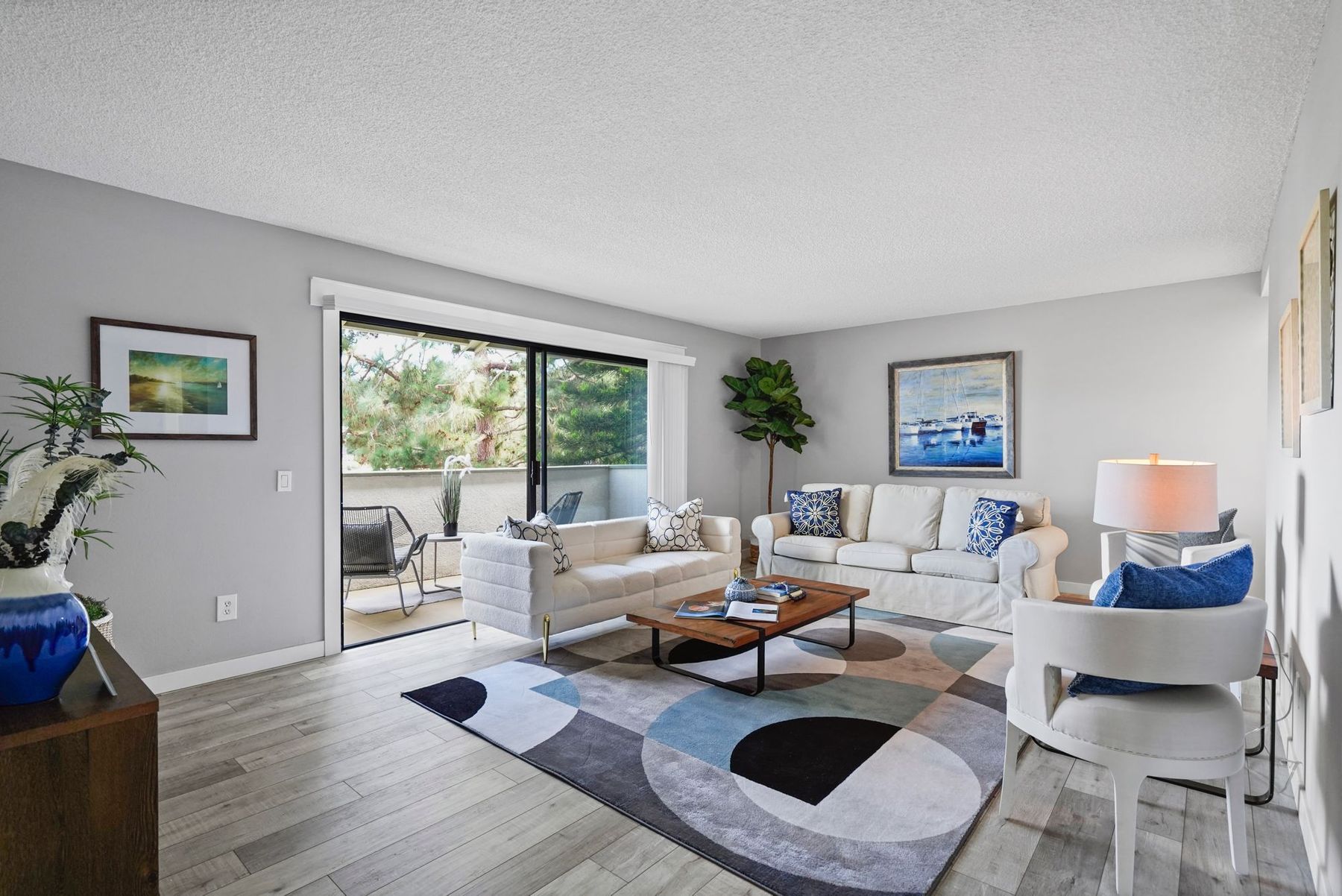 A staged Huntington Beach condo living room with a patterned rug and white sofa