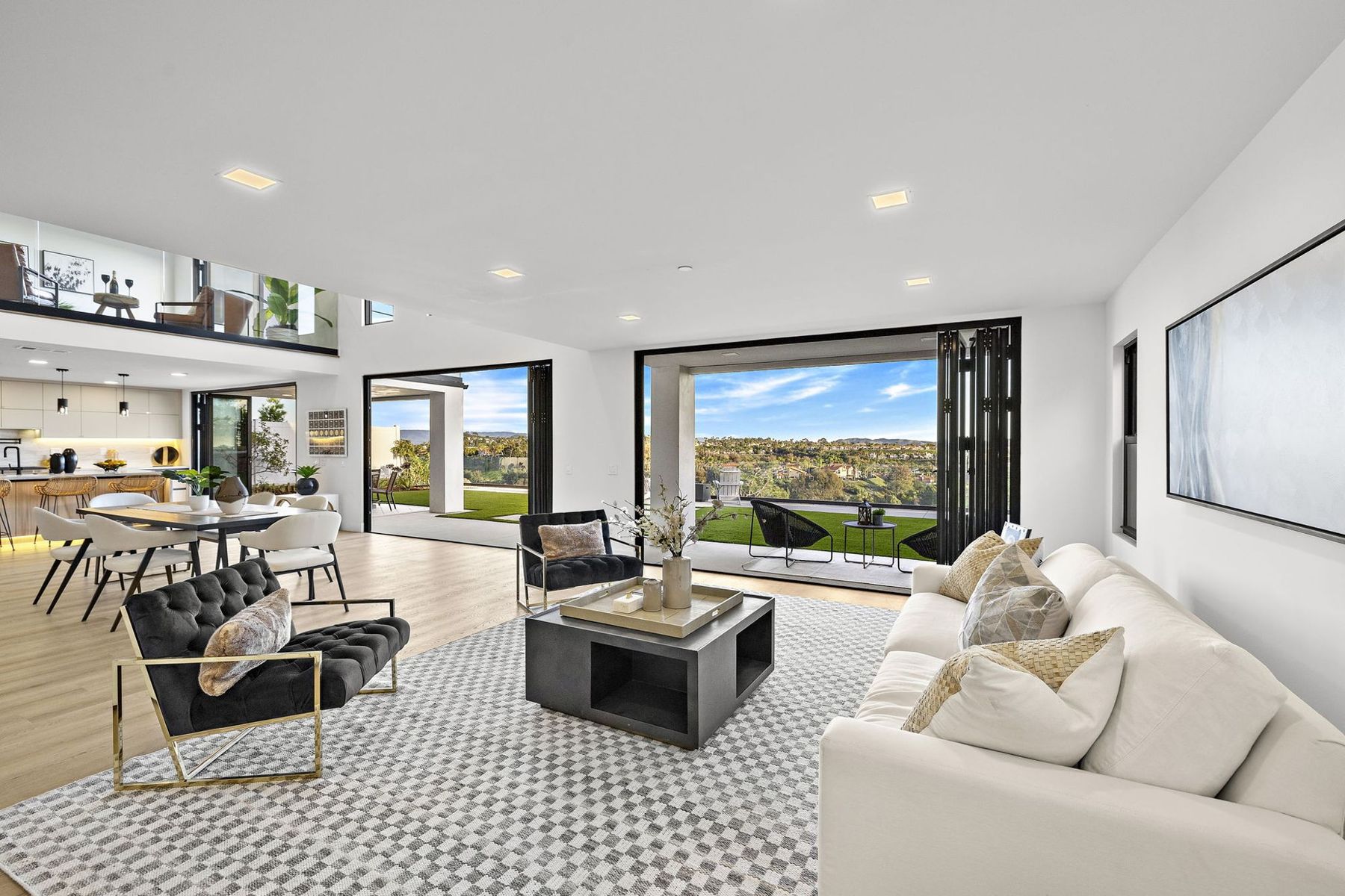 A staged Laguna Niguel great room with a view through wide glass doors