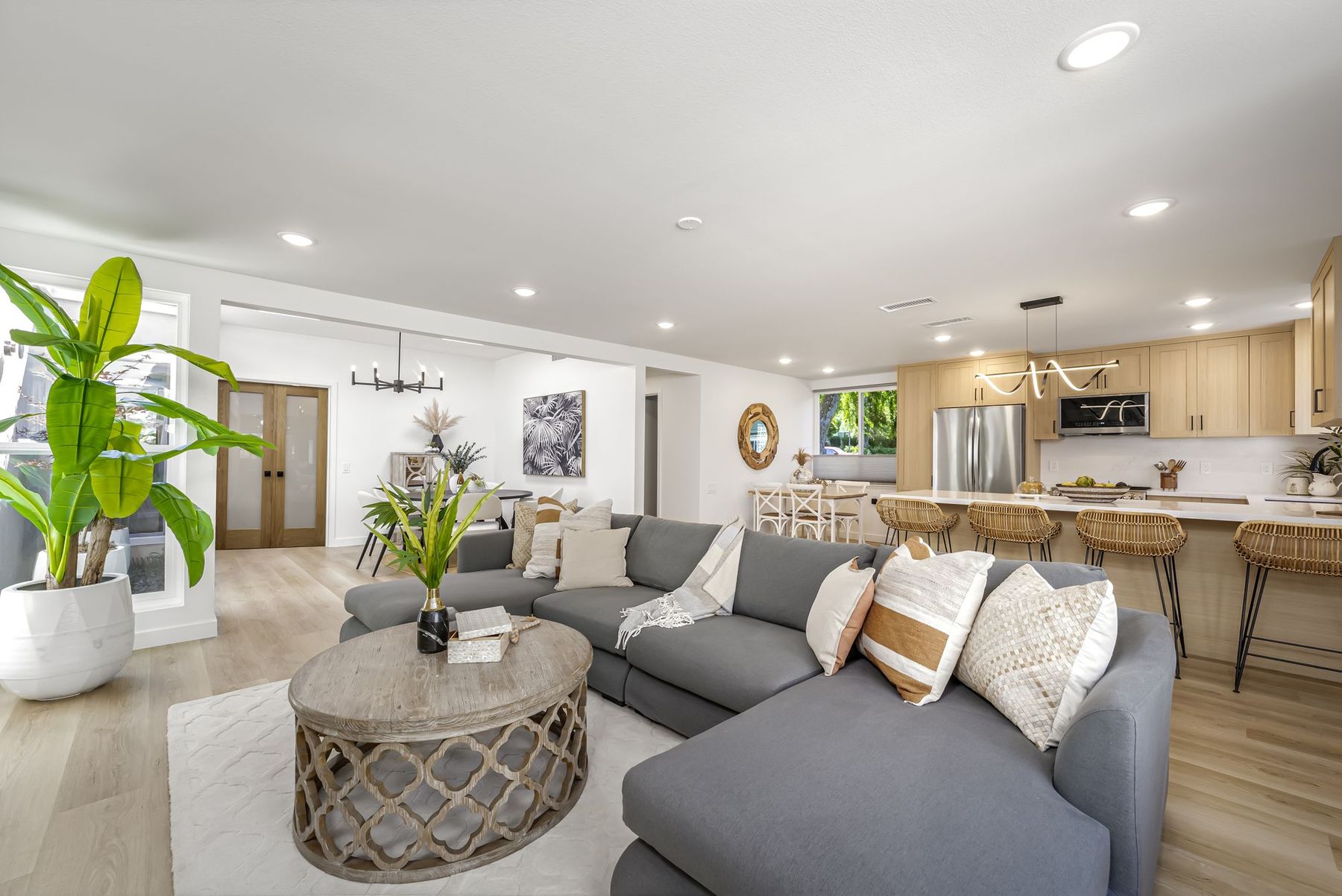 A staged Laguna Woods condo with a gray sectional and a round woven coffee table