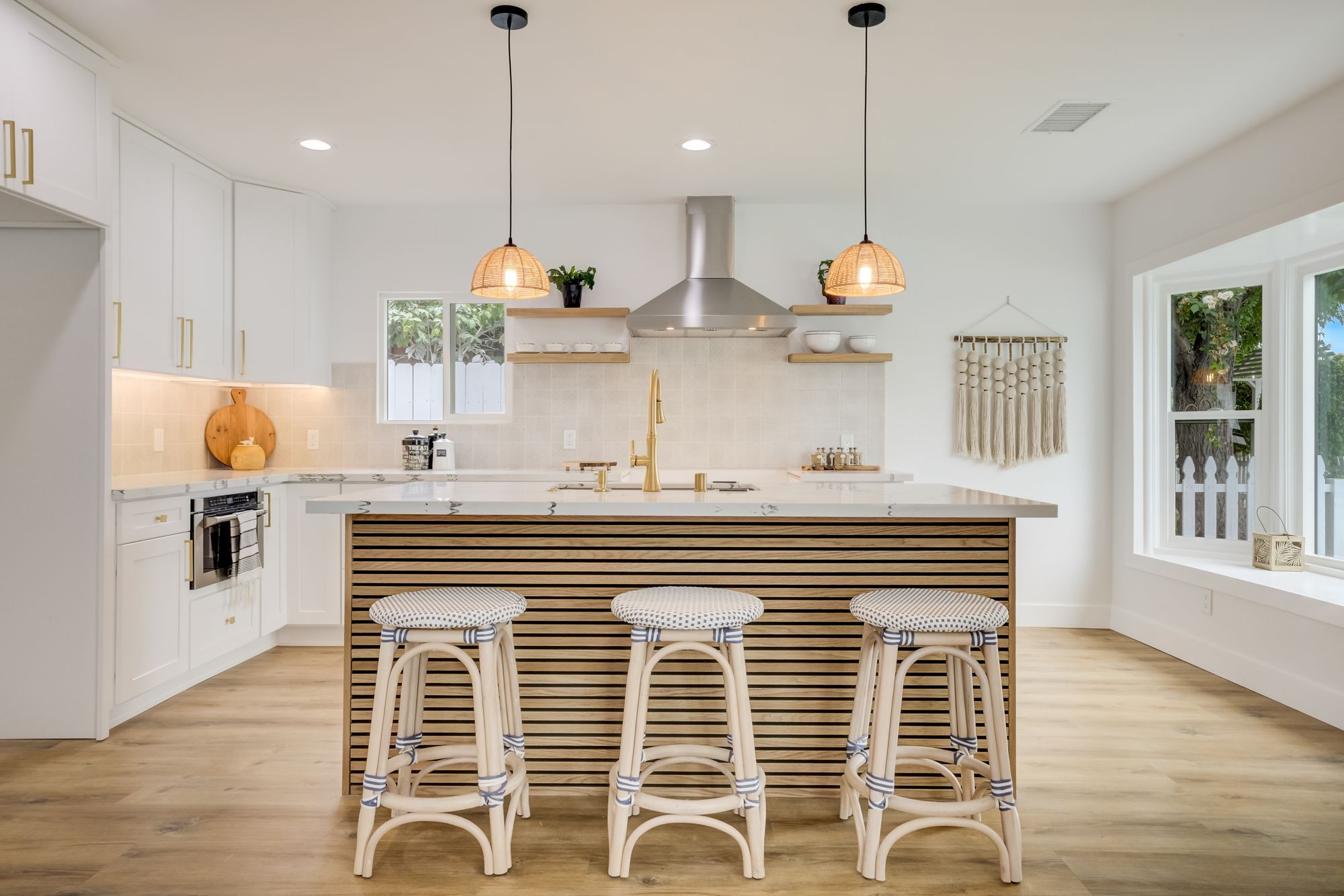 Contemporary kitchen with a wooden island, bar stools, and pendant lights