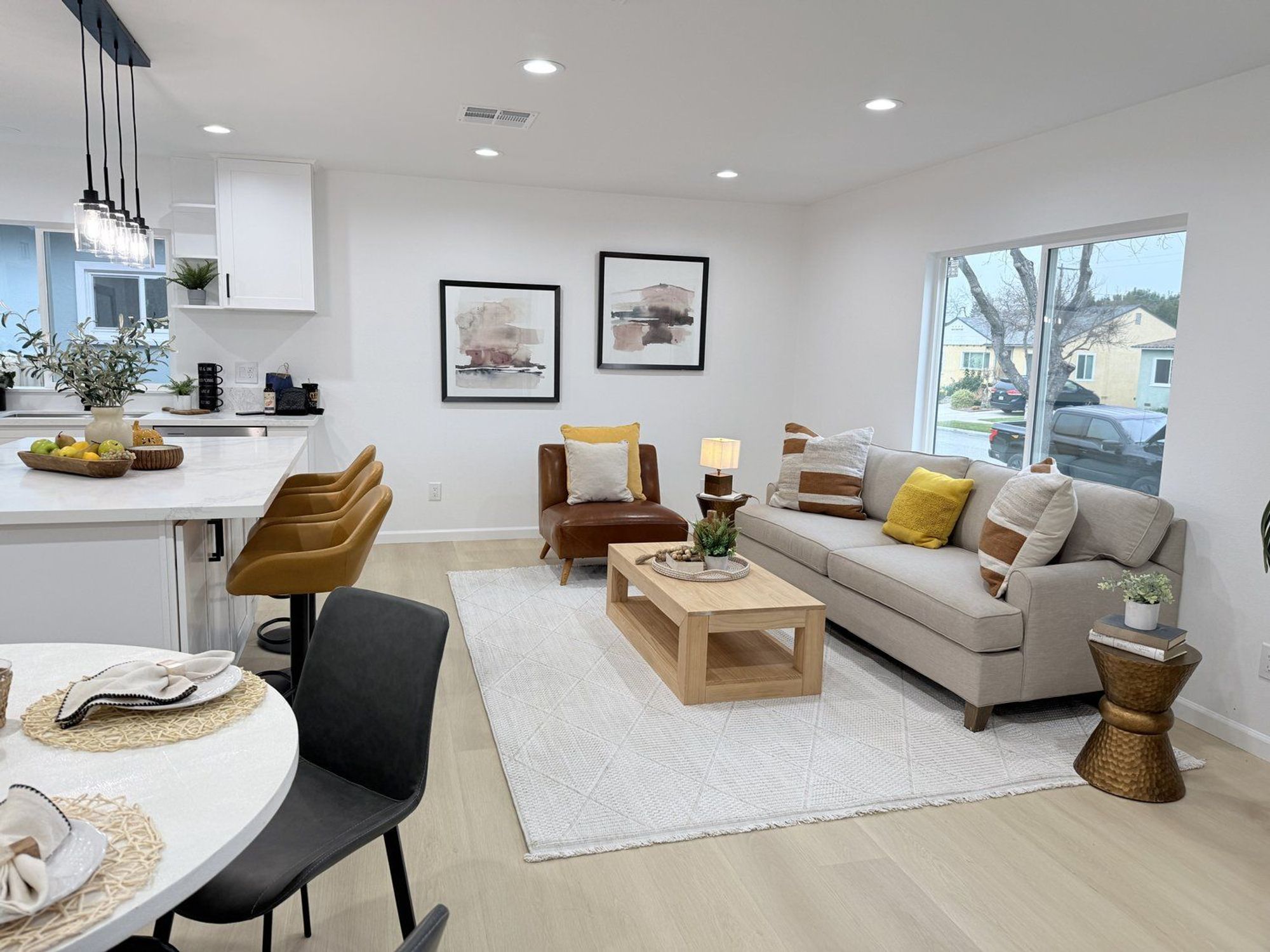 Contemporary living room with a beige sofa, leather armchair, and wooden coffee table in natural light