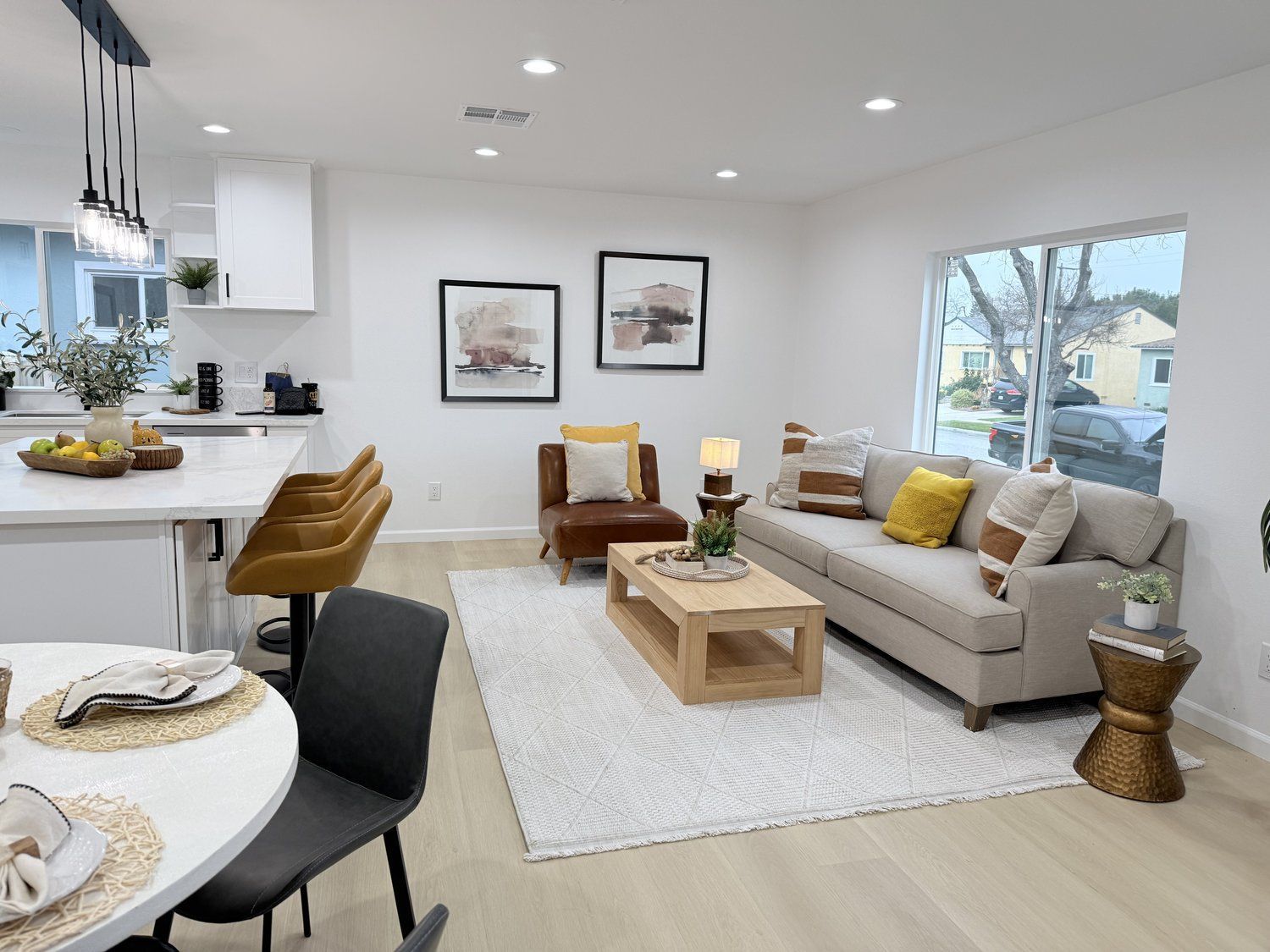 Contemporary living room with a beige sofa, leather armchair, and wooden coffee table in natural light