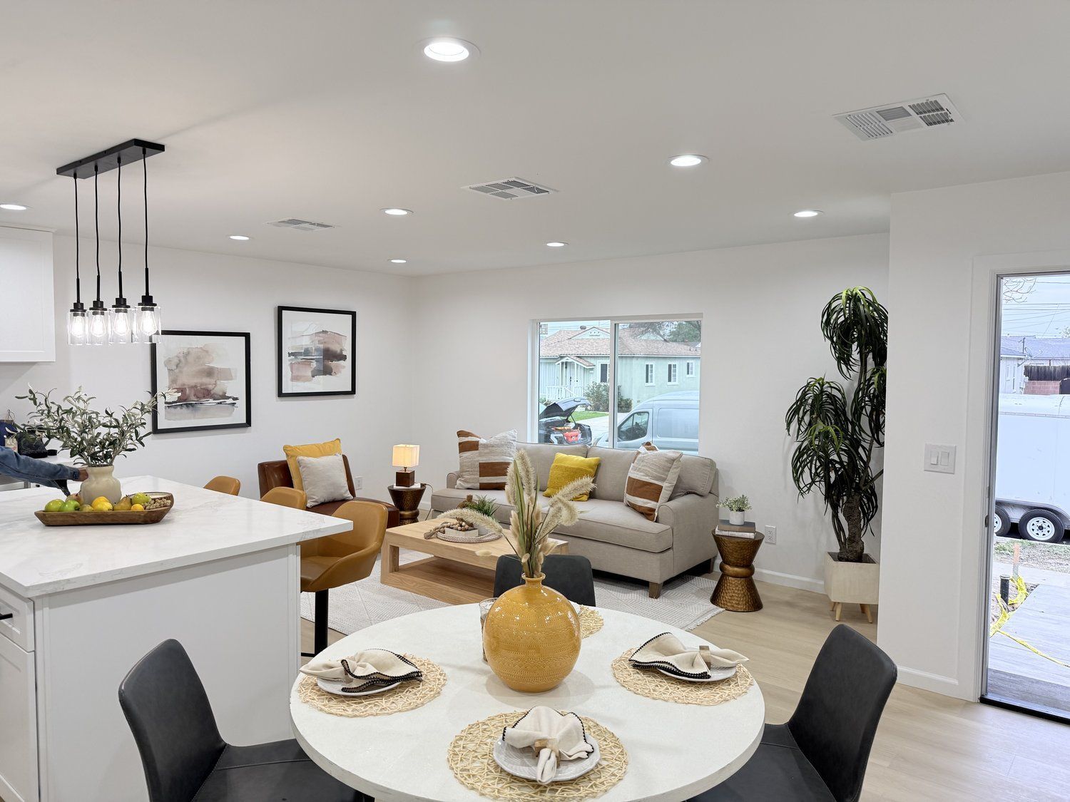 Light and airy living space with a beige sofa, dining table, and modern decor