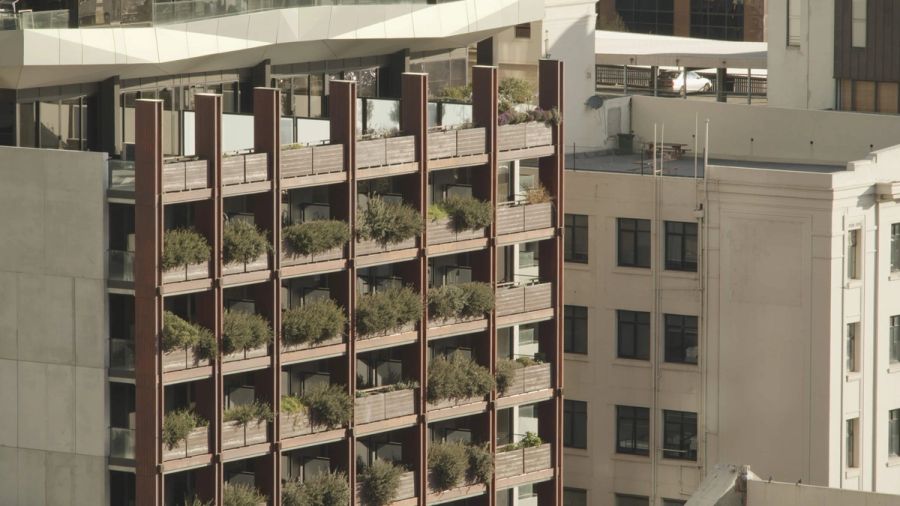 Multi-storey building facade with planted balconies