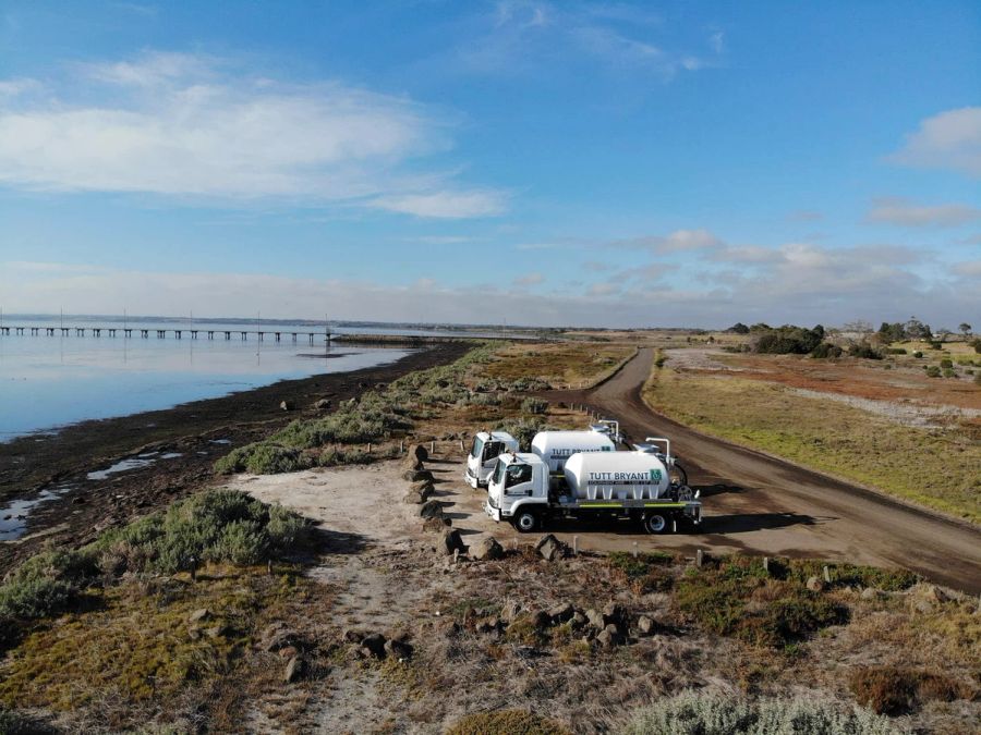 Aerial view of water trucks at a rural coastal site