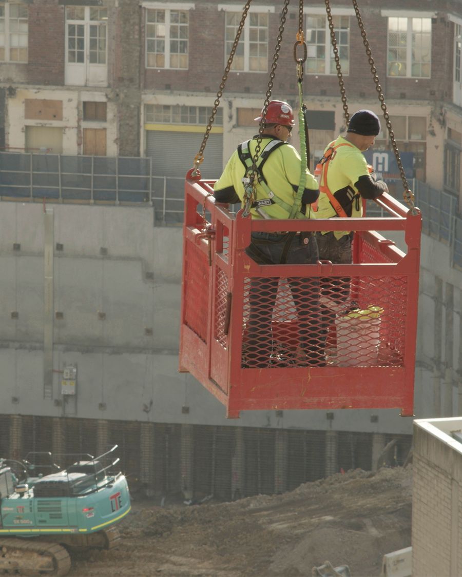 Two workers in a crane-suspended cage