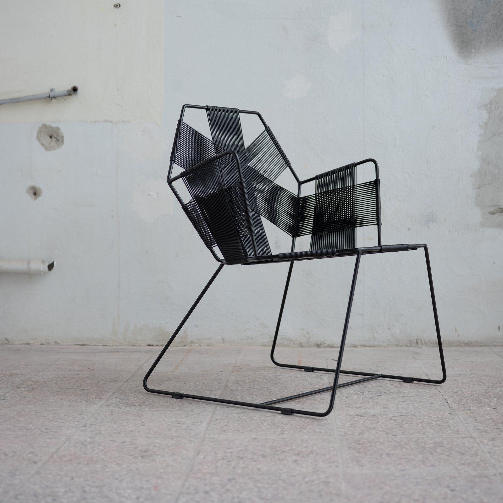 The Hexagon chair in front of a white studio wall.