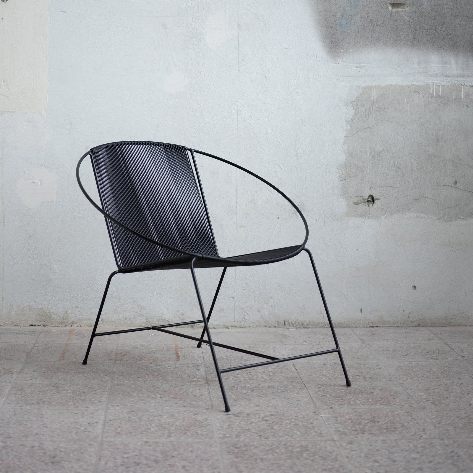 The Circle chair in front of a white studio wall.