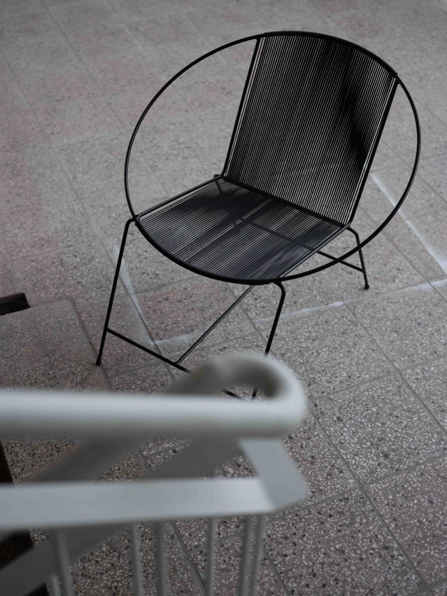 The Circle seen from above on a terrazzo floor, with a stair railing out of focus in the foreground.