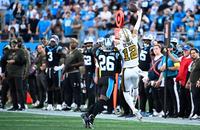 New Orleans Saints wide receiver Chris Olave (12) makes a one-handed catch as Carolina Panthers cornerback Chau Smith-Wade (26) defends during the fourth quarter at Bank of America Stadium.