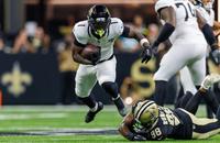 Aug 17, 2025; New Orleans, Louisiana, USA; Jacksonville Jaguars running back Travis Etienne Jr. (1) leaps to avoid the tackle of New Orleans Saints defensive end Chris Rumph II (98) during the first half at Caesars Superdome. 