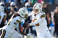 New Orleans Saints quarterback Tyler Shough hands the ball off to running back Alvin Kamara.