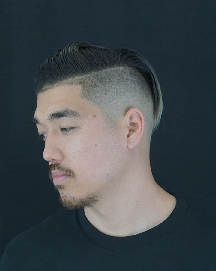 Side-part haircut with a fade and shaped facial hair