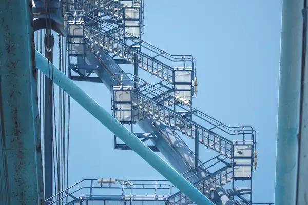 The stairway to a container crane cab at the Port of Mombasa against a blue sky
