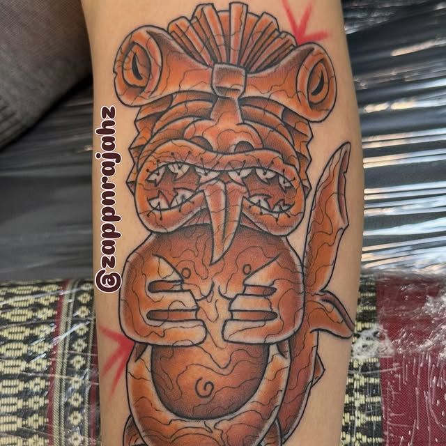 Bold Polynesian tiki tattoo by Tomo