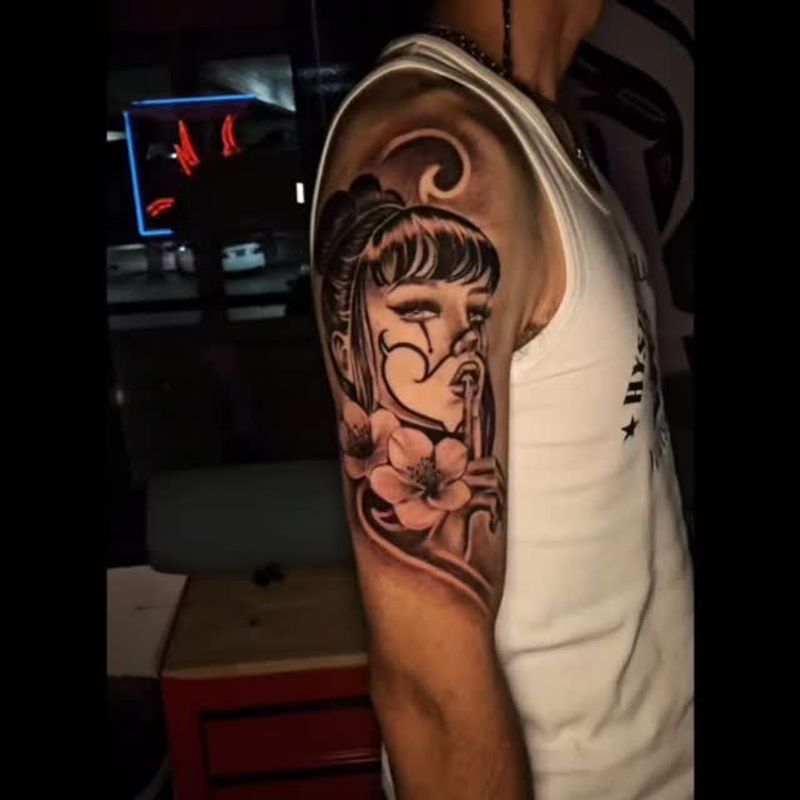 Black and grey gladiator helmet upper arm tattoo by Sergio