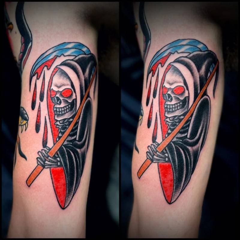Tattoo of a Grim Reaper with a scythe on the upper arm.