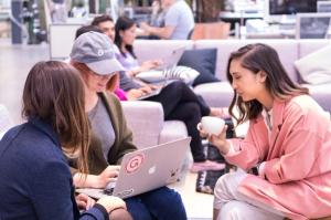 3 women in a huddle at the gusto office