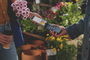 Two people tapping their iPhones together to make a transaction