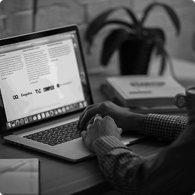 Computer sitting at desk with person nearby