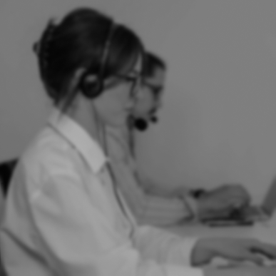 People with headsets sitting at desk with computers