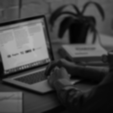 Computer sitting at desk with person nearby