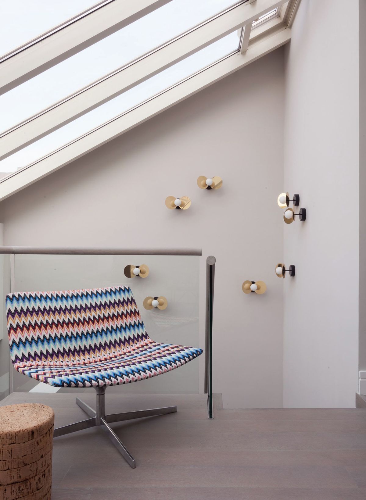 Skylight above patterned chair and sconces on wall