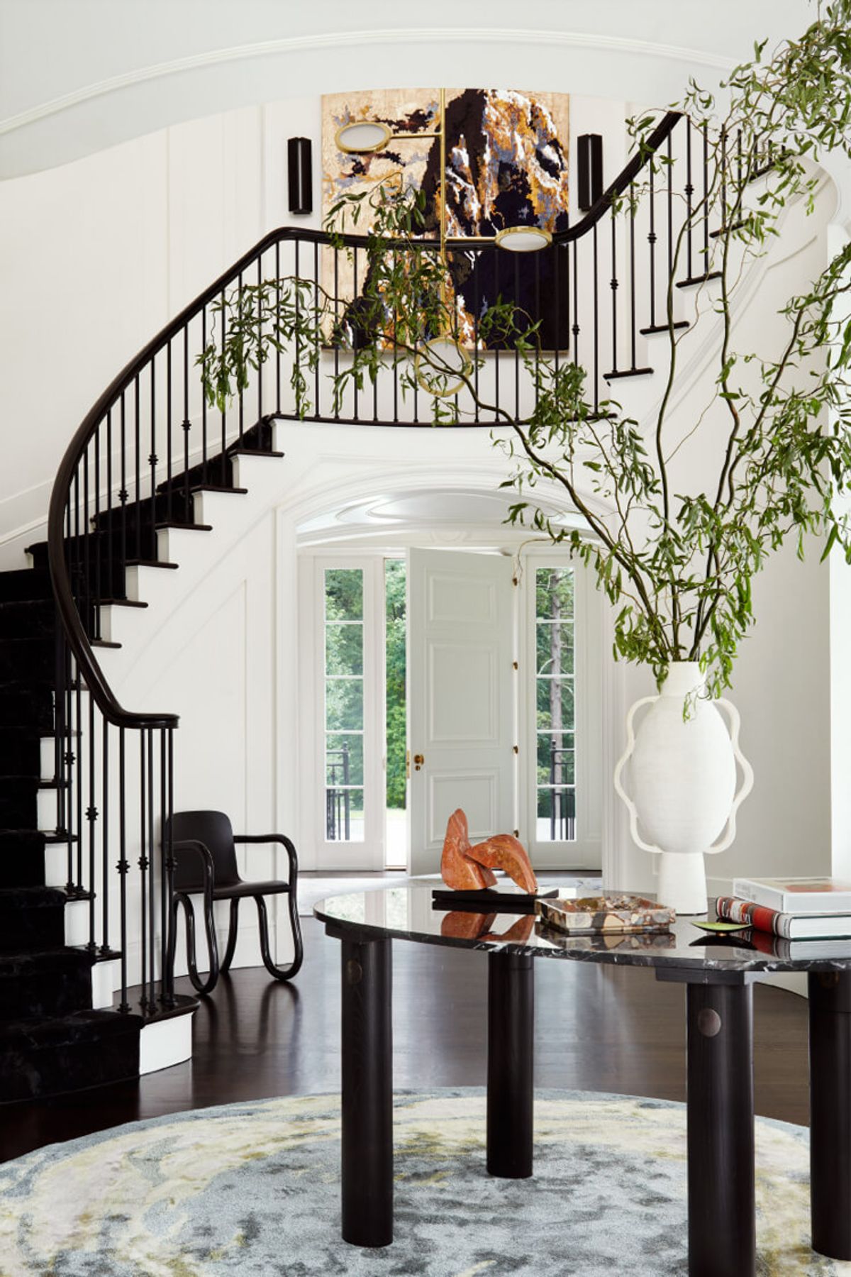 Foyer with stairwell, central table and artwork