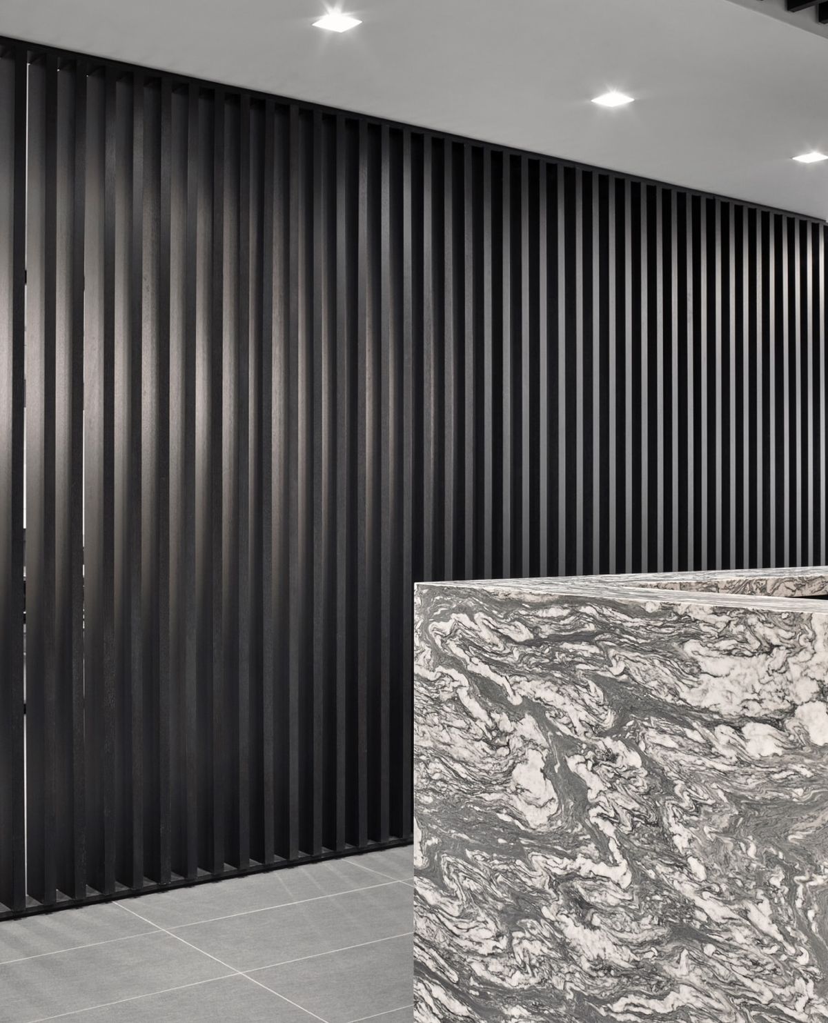 Detail of wall texture against marble reception desk and tile flooring