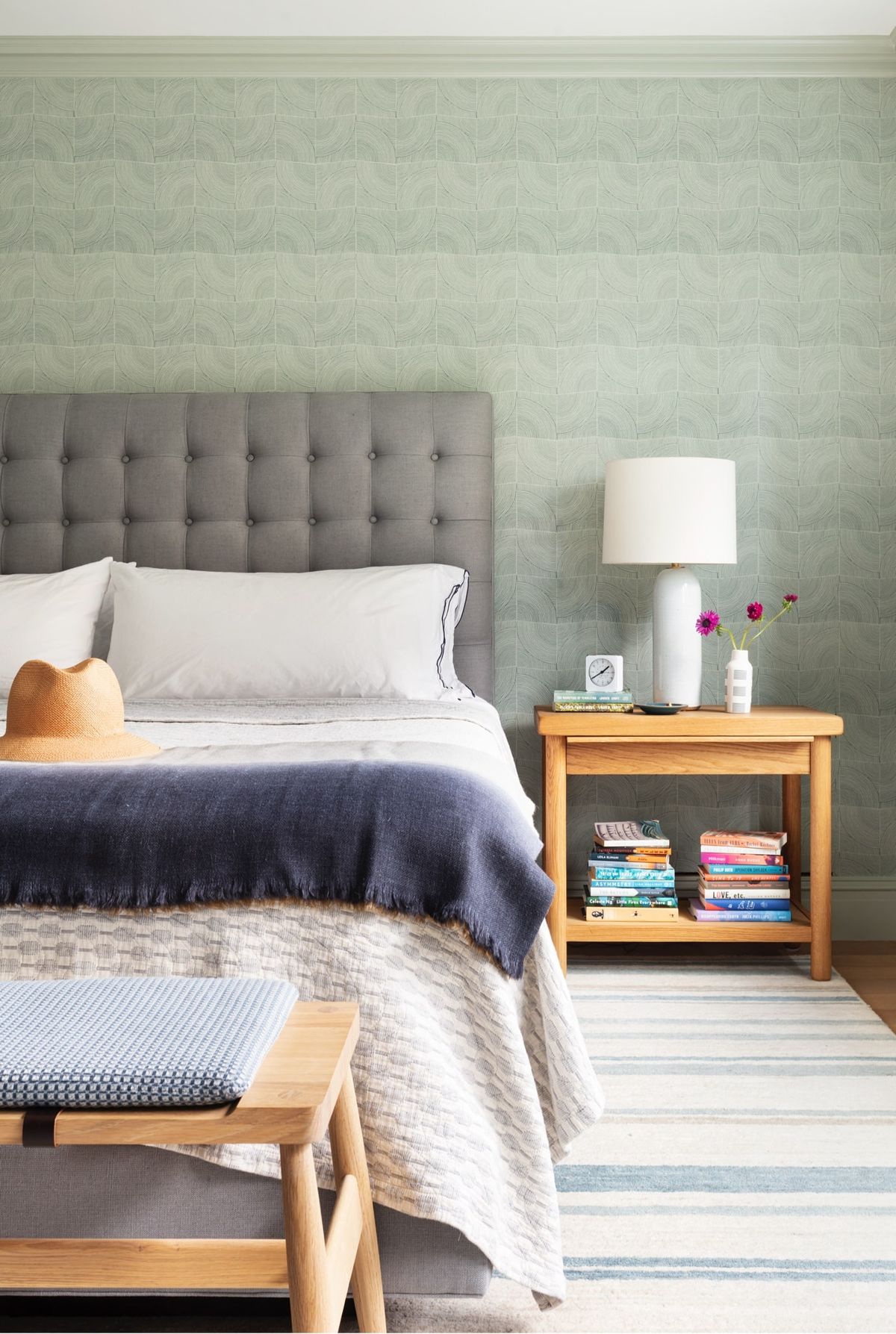 Primary bedroom vignette of bed, bench, side table
