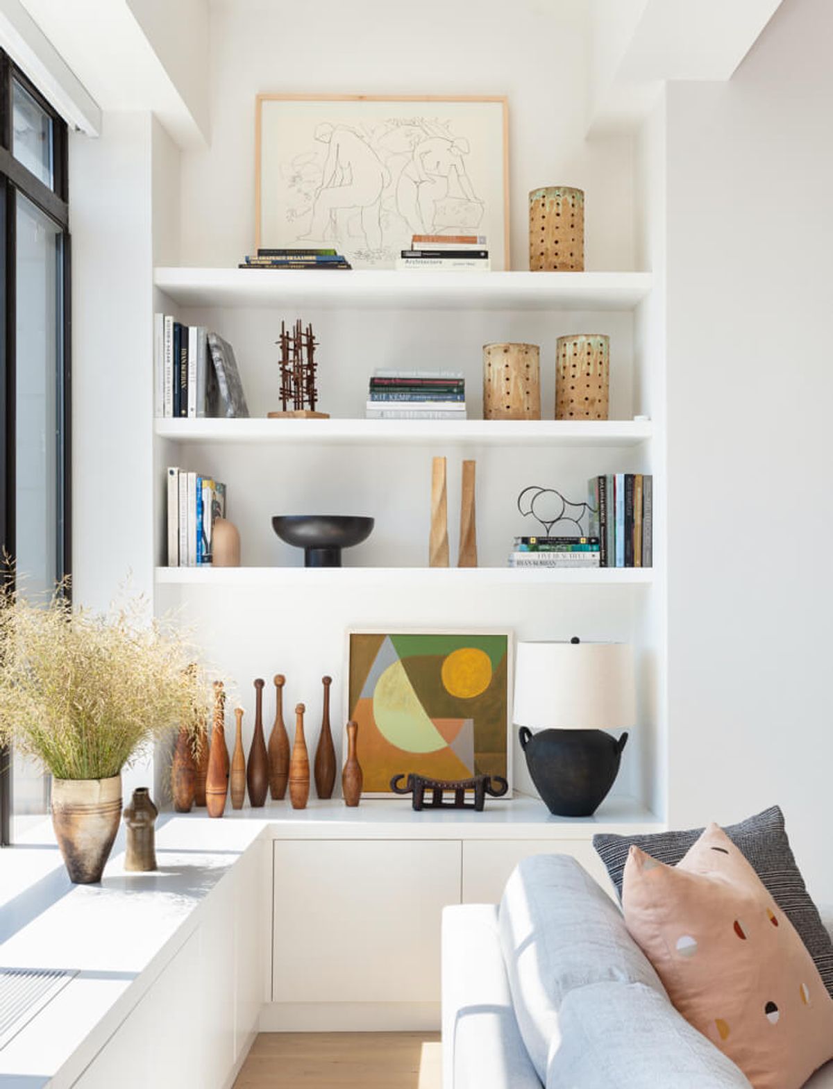 Built-in bookshelves above built-in credenza that sits beneath the big windows