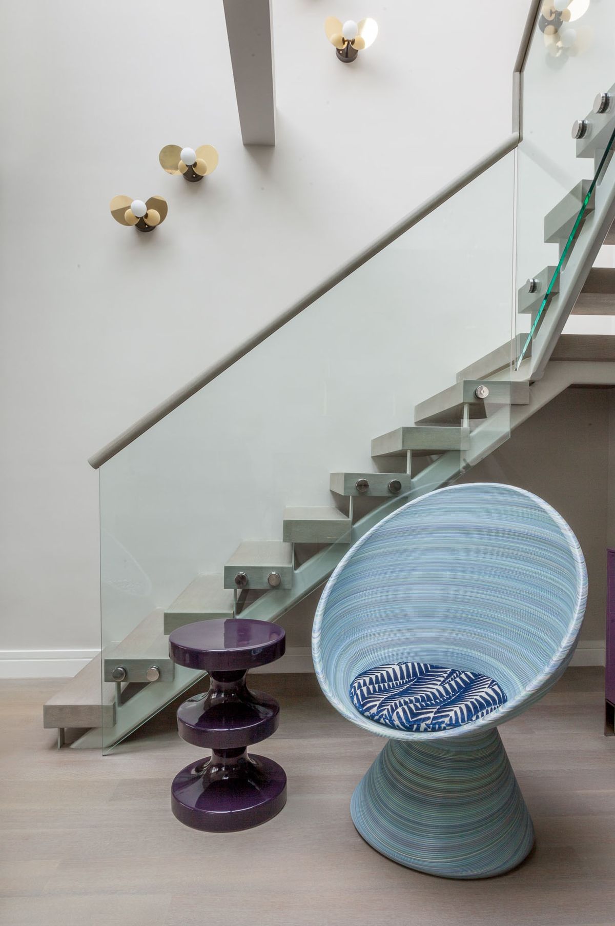 Detail of stairwell with chair and side table at the bottom