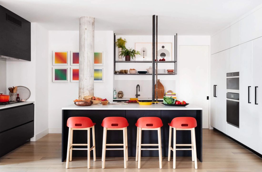 Modern kitchen with black cabinets, white walls, and pops of color