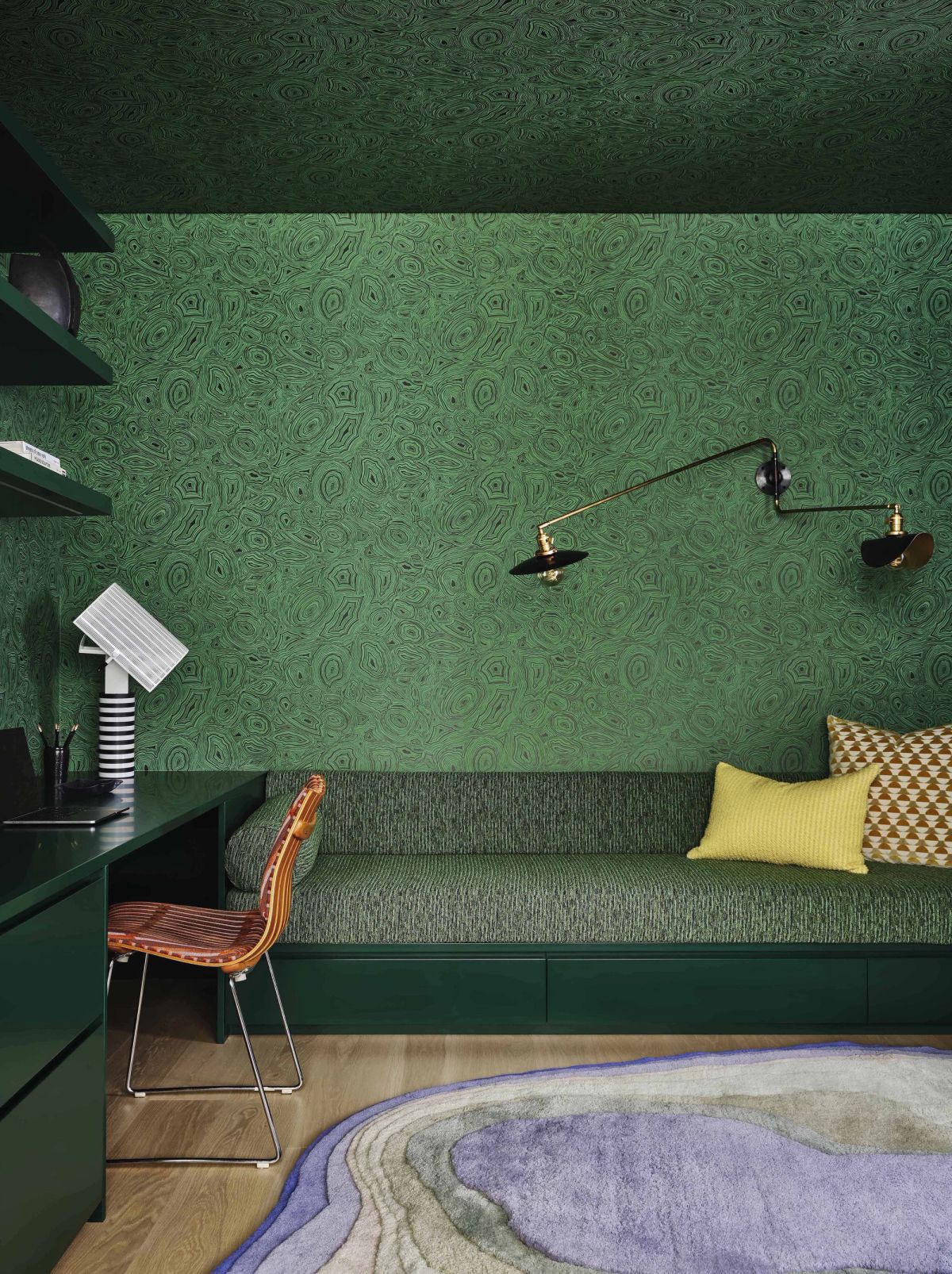 Shades of deep green cover the custom bench and built-in daybed and wallcoverings