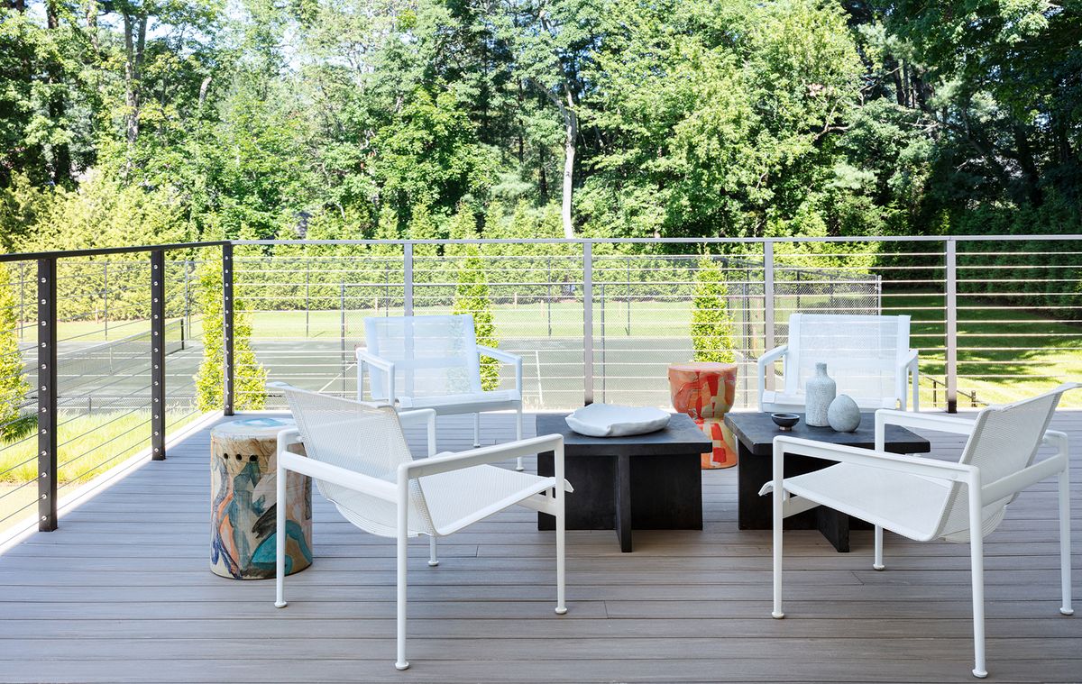 Deck with modern seating looking onto tennis court